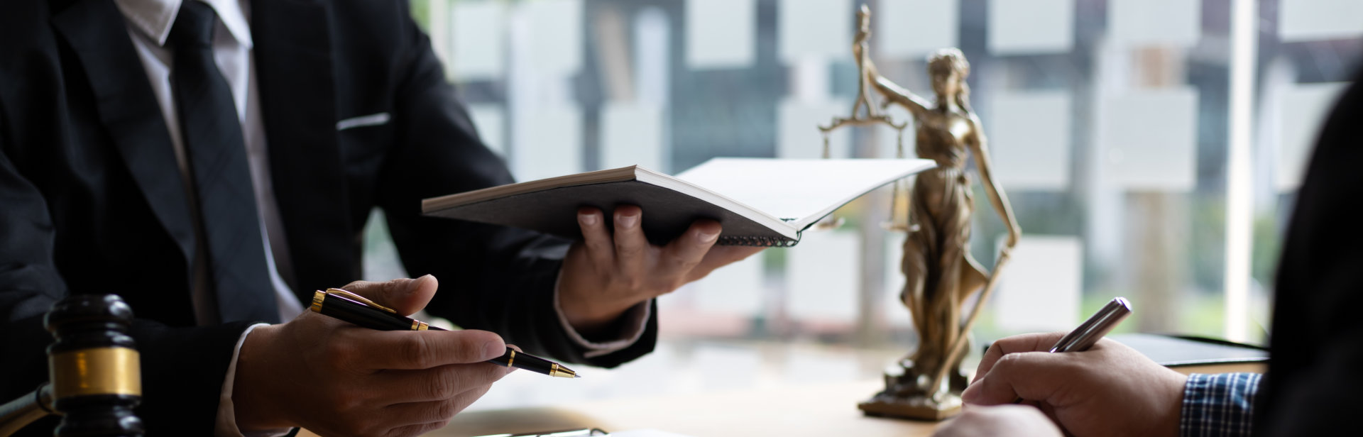 lawyer holding a notebook while talking to a client